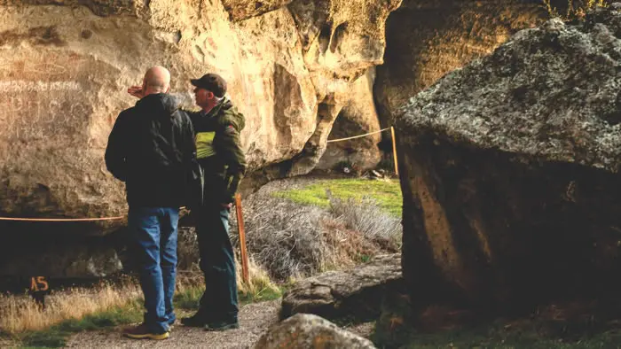 Guía turístico explicando la geología, glaciología y flora nativa de la Patagonia a orillas del lago