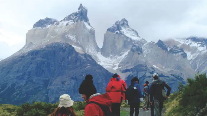 Mirador espectacular de los Cuernos del Paine. Turistas realizando caminata guiada en el Parque Nacional Torres del Paine.