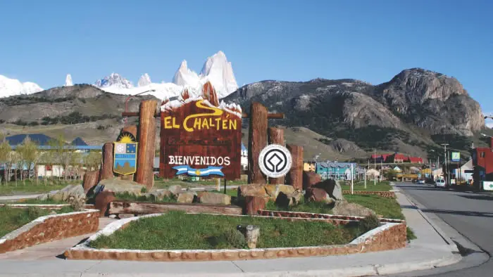 Cartel de bienvenida al pueblo de El Chaltén con el macizo Fitz Roy de fondo