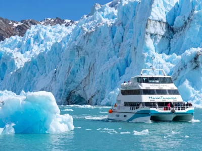 Catamarán navegando entre témpanos frente a los glaciares de El Calafate en el Lago Argentino